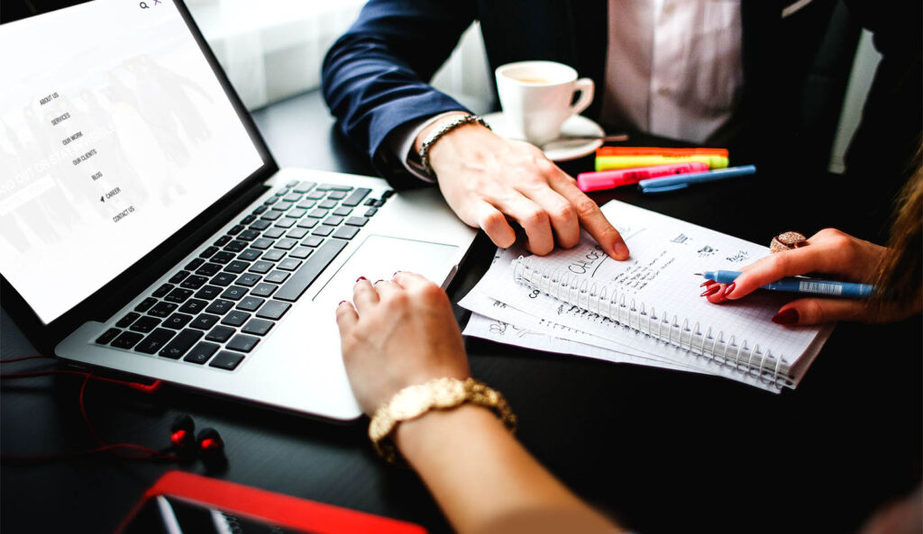 Business professionals discussing strategy with notes and laptop during a meeting